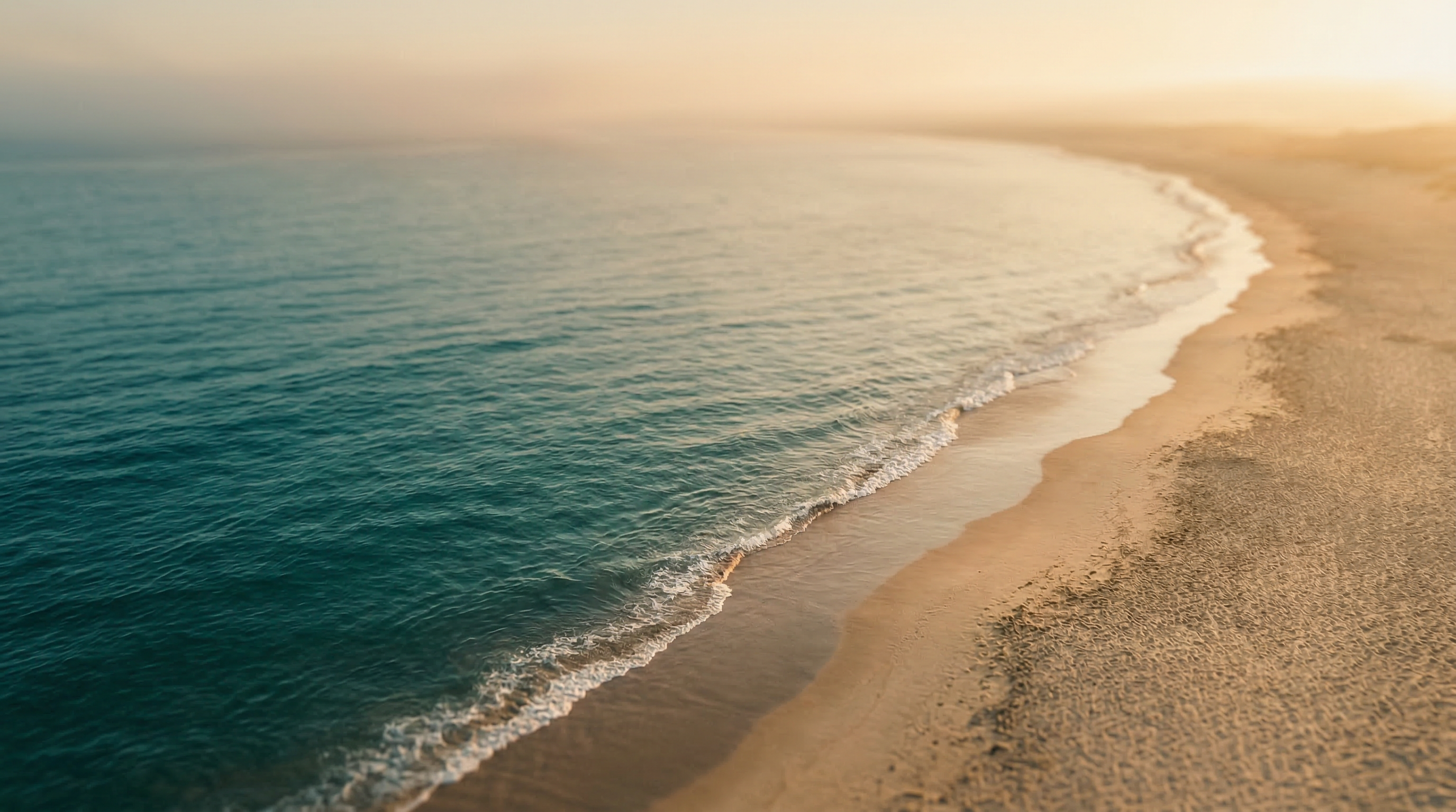 Calm ocean meeting coastline at golden hour